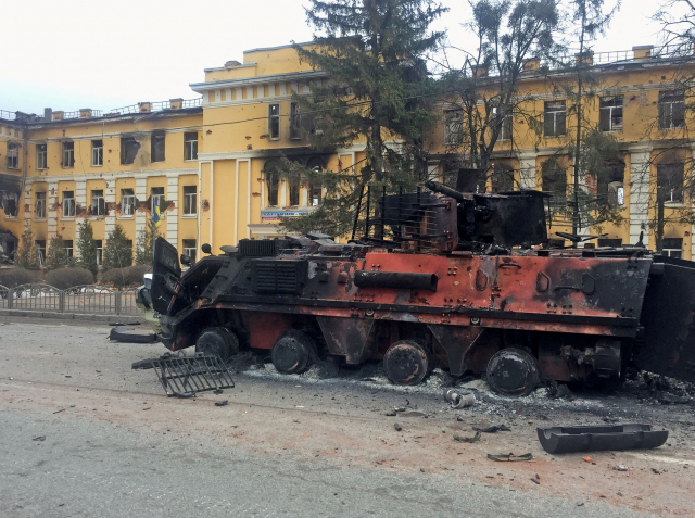 우크라이나 제2도시 하리코프의 한 학교 앞에 지난달 28일(현지시간) 포격을 받아 불탄 우크라이나군 병력수송장갑차(APC)가 멈춰서 있다. /하리코프 로이터=연합뉴스