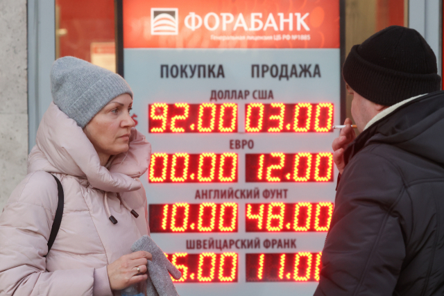 1일(현지 시간) 러시아 모스크바의 한 환전소 앞에서 시민들이 걱정스런 표정으로 환율표를 바라보고 있다. 타스연합뉴스