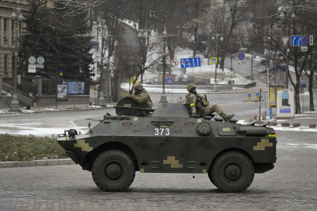 1일(현지시간) 우크라이나 수도 키예프에서 공습경보 사이렌이 울리는 가운데 텅 빈 도로를 군인들이 장갑차를 타고 달리고 있다./연합뉴스