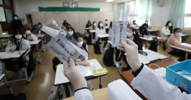 개학일인 2일 오전 울산시 북구 달천중학교에서 보건교사가 학생들에게 코로나19 신속항원검사 키트를 배부한 후 사용법을 알려주고 있다. /연합뉴스