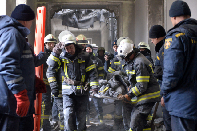 1일(현지시간) 구조대원들이 러시아군의 미사일 공격을 받아 파괴된 우크라이나 제2 도시인 하리코프의 시청사 밖으로 사망자의 시신을 옮기고 있다. /연합뉴스