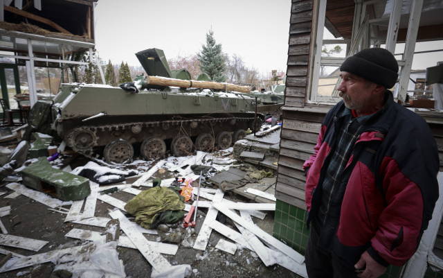 1일(현지시간) 우크라이나 수도 키예프 외곽 부차에서 한 주민이 파괴된 러시아 군용 차량의 잔해를 바라보고 있다. /AP=연합뉴스