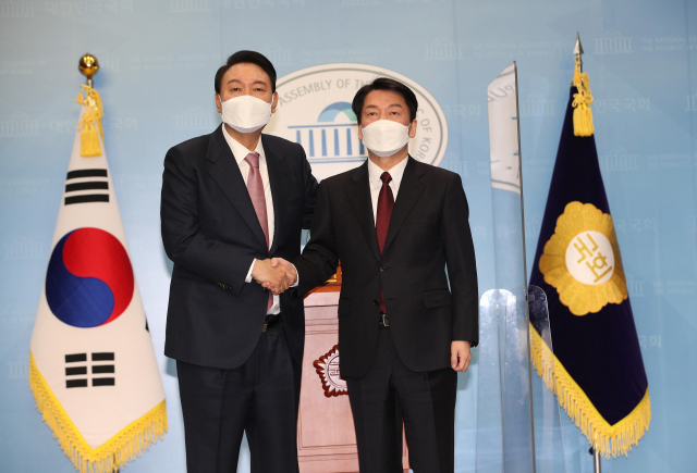 국민의힘 윤석열 대선 후보와 국민의당 안철수 대선 후보가 3일 오전 국회 소통관에서 단일화 기자회견을 마친 뒤 악수하고 있다. /연합뉴스