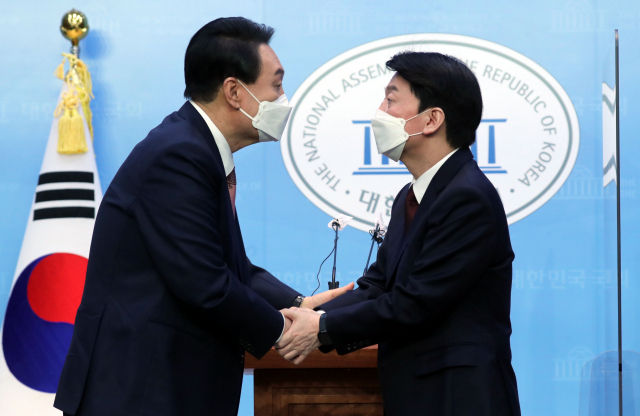 윤석열(왼쪽) 국민의힘 대선 후보와 안철수 국민의당 대선 후보가 3일 오전 국회 소통관에서 단일화 기자회견을 마치며 악수하고 있다. 성형주 기자