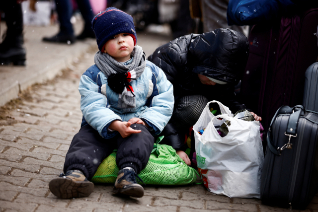 3일(현지시간) 폴란드 국경도시 코르쵸바에 마련된 임시 수용소 밖에서 피란 온 우크라이나의 한 어린이가 오도카니 앉아 있다. /연합뉴스