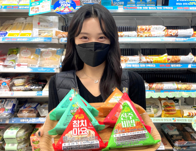 GS25 모델이 3일 20년 만에 리뉴얼한 ‘풀 삼각김밥’을 소개하고 있다./사진제공=GS리테일