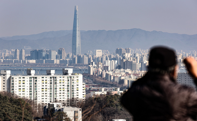 3일 오후 서울 남산 전망대를 찾은 시민이 강남구와 송파구 한강 근처 아파트를 바라보고 있다. 연합뉴스