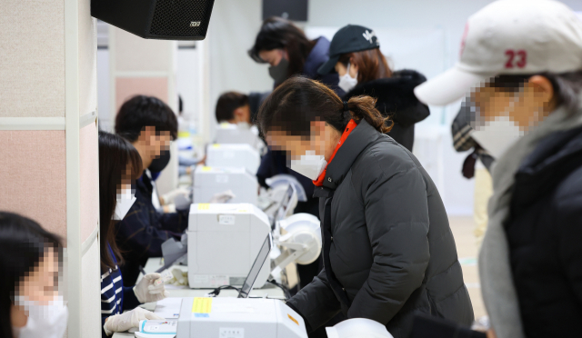 제20대 대선 사전투표 둘째 날인 5일 서울 광진구 자양 제3동 주민센터에 마련된 사전투표소를 찾은 시민들이 투표인명부 확인 및 투표용지를 수령하고 있다. /연합뉴스