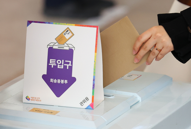20대 대선 사전투표 이틀째인 5일 오전 서울역 대합실에 마련된 사전투표소를 찾은 한 시민이 투표함에 투표용지를 넣고 있다. /연합뉴스