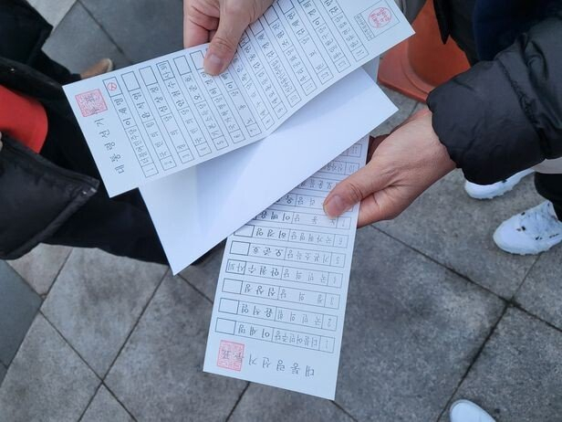 지난 5일 서울 은평구 신사1동 투표소의 확진자 임시 기표소에서 한 유권자가 자신의 투표용지(아래)를 담을 봉투(가운데) 속에서 '1번 이재명 더불어민주당 후보'에 기표된 투표용지(위)를 발견하면서 논란이 커지고 있다. 사진 제공=독자