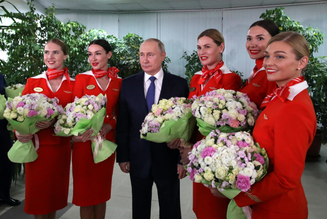 블라디미르 푸틴 러시아 대통령이 5일 세계 여성의 날(8일)을 앞두고 모스크바 근교에 있는 국영항공사 아에로플로트 항공학교를 방문해 여승무원들과 기념사진을 찍고 있다./AP=연합뉴스