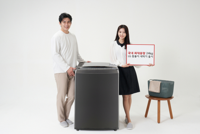 LG전자 모델들이 국내 최대 용량을 자랑하는 통돌이 세탁기를 소개하고 있다./사진제공=LG전자