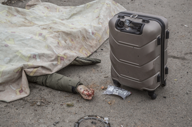 지난 6일(현지시간) 우크라이나 이르핀에서 키이우를 향한 피란길에 올랐던 일가족이 러시아군의 공격을 받고 쓰러져 있다. /EPA연합뉴스