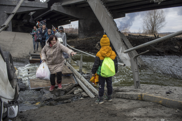 지난 6일(현지시간) 우크라이나 수도 키이우 인근 이르핀 시에서 민간인들이 파손된 다리를 건너고 있다./ EPA 연합뉴스