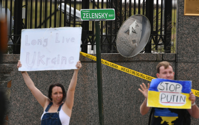 7일(현지 시간) 미국 수도 워싱턴DC의 러시아 대사관 앞에서 시민들이 볼로디미르 젤렌스키 우크라이나 대통령의 이름을 따 ‘젤렌스키 거리’라고 쓴 모의 도로표지판을 걸어 놓고 반전 시위를 벌이고 있다. AFP연합뉴스