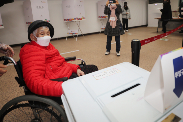 제20대 대통령 선거일인 9일 오전 광주 북구 문흥1동 행정복지센터에 마련된 투표소에서 광주 최고령자인 박명순(118) 씨가 아들의 도움을 받아 기표지를 투표함에 넣고 있다. 광주=연합뉴스