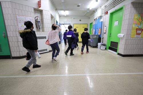마스크 착용 의무화 조치가 해제된 미국 뉴욕의 한 초등학교에 학생들이 들어서고 있다./AFP 연합뉴스