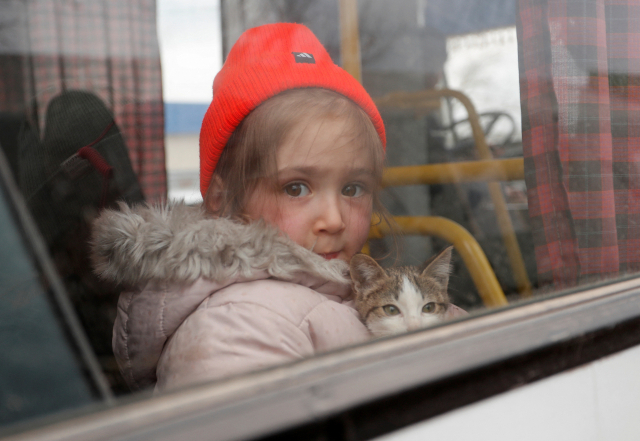 우크라이나 남부 항구 도시인 마리우폴에서 8일(현지 시간) 한 3세 여아가 고양이를 품에 안은 채 피란 버스에 올라 타 있다. 로이터연합뉴스