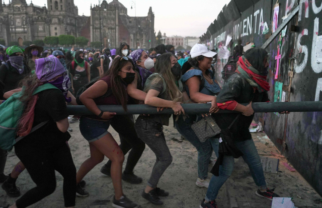 세계 여성의 날인 8일(현지 시간) 멕시코 수도 멕시코시티에서 여성 안전 대책을 요구하는 시위대가 대통령궁과 연방정부 건물 앞에 설치된 펜스를 무너뜨려 하고 있다. 멕시코에서는 하루 평균 10명 이상의 여성이 살해된다. AFP연합뉴스