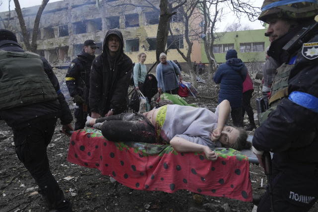 9일(현지 시간) 러시아군의 포격을 받은 우크라이나 남부 마리우폴의 한 산부인과 앞에서 부상을 당한 한 임신부가 들것에 실려 옮겨지고 있다. AP연합뉴스