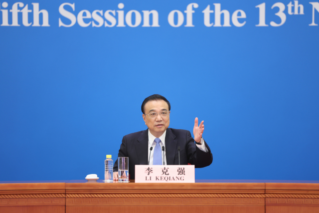 리커창 중국 총리가 11일 베이징 인민대회당에서 열린 화상 기자회견에서 기자들의 질문에 답하고 있다. 신화연합