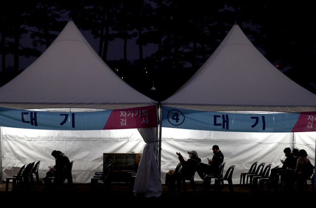 14일 오후 서울 마포구 월드컵공원 평화광장에 마련된 코로나19 임시 선별검사소에서 신속항원검사를 마친 시민들이 검사 결과를 기다리고 있다. 연합뉴스