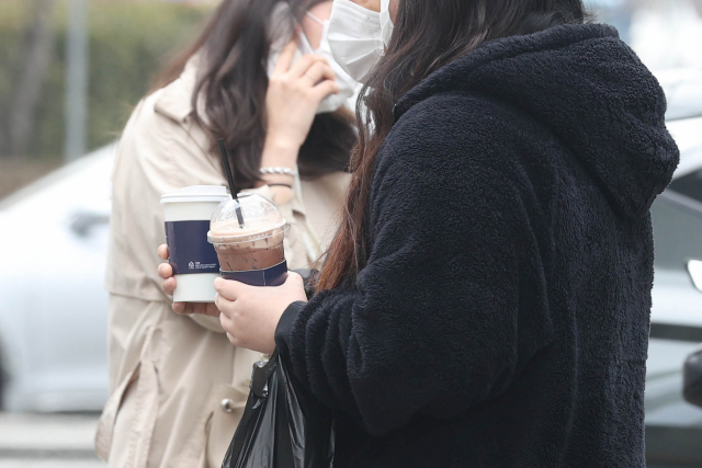 낮 기온이 크게 오른 지난달 서울 광화문역 인근에서 시민들이 서로 다른 음료를 들고 있다./연합뉴스