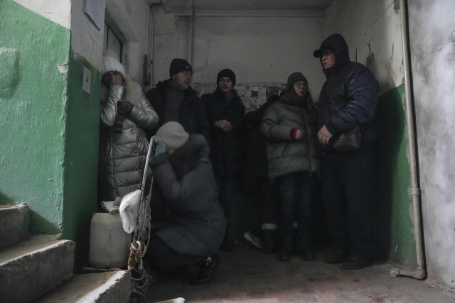 13일(현지시간) 우크라이나 마리우폴의 한 아파트 입구에서 사람들이 포격을 피하고 있다. AP연합뉴스