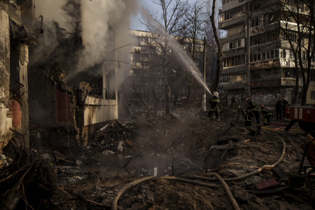 우크라이나 소방관들이 15일(현지시간) 수도 키이우에서 폭탄 공격으로 붕괴된 아파트 화재 현장에서 진화 작업을 하고 있다. AP연합뉴스