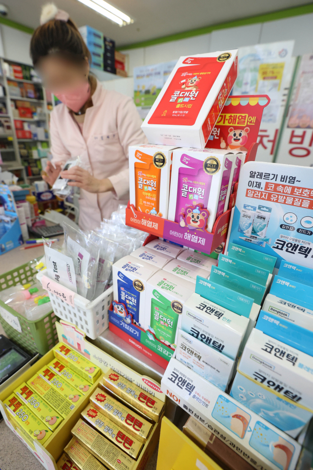 서울의 한 약국에서 관계자가 소아용 해열제와 감기약 등 소아 재택치료 키트를 진열하고 있다. 연합뉴스