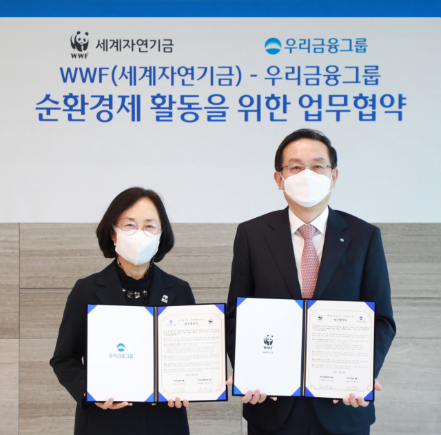 손태승(오른쪽) 우리금융그룹 회장과 홍윤희 한국세계자연기금(WWF) 사무총장이 16일 서울 중구 우리금융그룹 본사에서 순환경제 활동을 위한 업무협약을 체결한 뒤 기념촬영 하고 있다. 우리금융