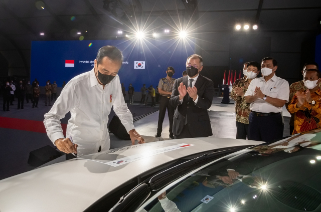 조코 위도도(왼쪽) 대통령이 16일(현지시간) 인도네시아 현대차 공장 준공식에서 아이오닉 5 차량에 서명을 하고 있다. 정의선(왼쪽 두번째) 현대차 회장과 현지 직원들이 박수를 치고 있다. /사진제공=현대차