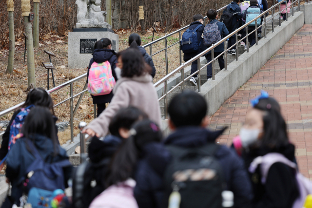 초등학생들이 지난 14일 서울 시내 한 초등학교로 등교하고 있다. 연합뉴스