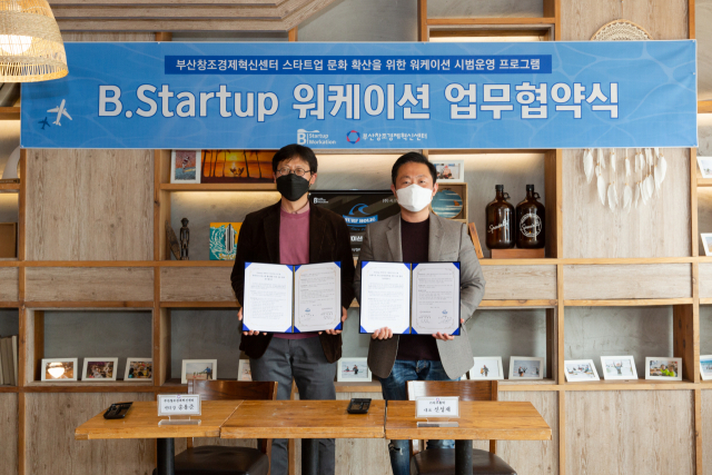 송용준(왼쪽) 부산창조경제혁신센터장과 신성재 서프홀릭 대표가 B.Startup 워케이션 인프라 구축을 위한 협약을 체결하고 기념촬영을 하고 있다./사진제공=부산창조경제혁신센터