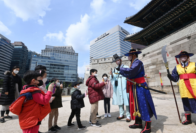 20일 서울 중구 숭례문에서 열린 '숭례문 호패놀이' 행사에 참가한 어린이들이 파수꾼에게 호패를 꺼내 보이고 있다. 호패놀이는 조선시대 신분증과 같은 호패를 직접 만들어 파수대장에게 보여주고 숭례문을 통과하는 체험 행사로 4월10일까지 매주 주말마다 열린다./권욱 기자 2022.03.20