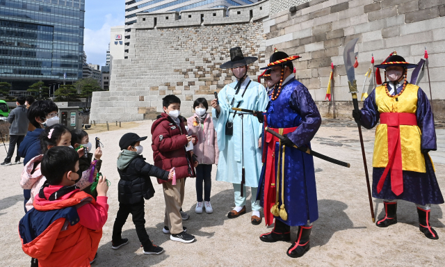 20일 서울 중구 숭례문에서 열린 '숭례문 호패놀이' 행사에 참가한 어린이들이 파수꾼에게 호패를 꺼내 보이고 있다. 호패놀이는 조선시대 신분증과 같은 호패를 직접 만들어 파수대장에게 보여주고 숭례문을 통과하는 체험 행사로 4월10일까지 매주 주말마다 열린다./권욱 기자 2022.03.20