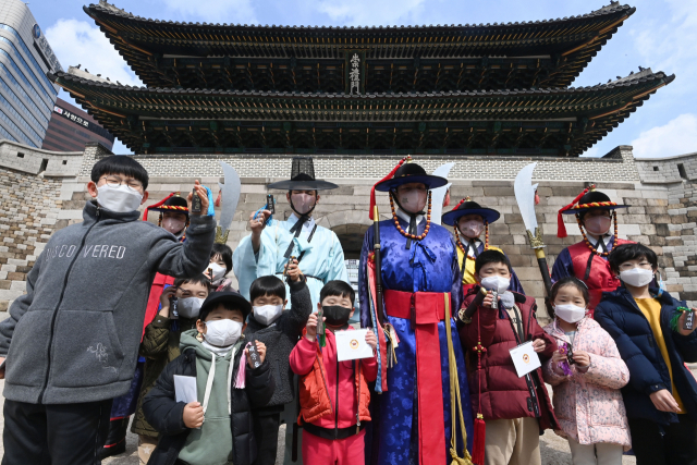 20일 서울 중구 숭례문에서 열린 '숭례문 호패놀이' 행사에 참가한 어린이들이 호패를 꺼내 보이며 포즈를 취하고 있다. 호패놀이는 조선시대 신분증과 같은 호패를 직접 만들어 파수대장에게 보여주고 숭례문을 통과하는 체험 행사로 4월10일까지 매주 주말마다 열린다./권욱 기자 2022.03.20