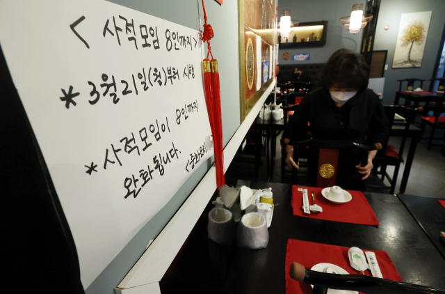 지난 20일 서울 양천구의 한 중식당에 21일부터 시행되는 사회적 거리두기 조정 관련 8인 단체손님 입장이 가능하다는 내용의 안내문이 부착돼 있다. /연합뉴스