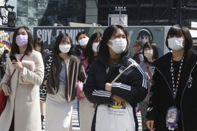 코로나19 확산 방지를 위한 비상조치인 '만연 방지 등 중점조치' 마지막 날인 21일 마스크를 쓴 사람들이 일본 가나가와현 요코하마시에서 이동 중이다. AP 연합뉴스