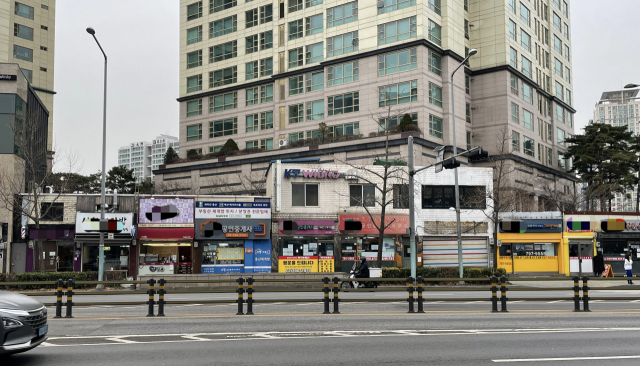 지난 21일 국방부 청사 앞 거리에 ‘재개발’이라 써붙인 공인중개사들이 줄지어 늘어서 있다. 박신원 기자