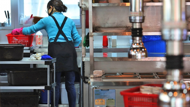 한 식당 종업원이 주방에서 그릇을 정리하고 있다. 연합뉴스