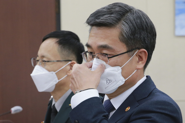 서욱(오른쪽) 국방부 장관이 지난 22일 국회에서 열린 국방위원회 전체회의에 참석해 마스크를 고쳐쓰고 있다./ 성형주 기자