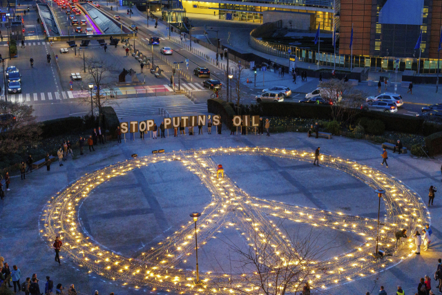 국제 시민단체인 ‘아바즈’ 회원들이 22일(현지 시간) 벨기에 브뤼셀의 유럽연합(EU) 본부 앞 광장에 촛불과 전등을 이용해 평화를 의미하는 거대한 상징물을 만들고 있다. 오는 24일 브뤼셀에서 조 바이든 미국 대통령과 유럽연합(EU)·북대서양조약기구(NATO·나토) 정상 간 회담이 개최될 예정인 가운데, 아바즈는 우크라이나 전쟁 종식과 러시아산 원유 수입 중단을 촉구했다. AP연합뉴스