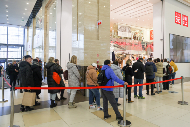 유니클로가 러시아 내 영업 중단 소식을 전하자, 지난 11일(현지시간) 모스코바의 한 쇼핑센터 내 유니클로 매장 앞에서 고객들이 오픈 전부터 줄을 서서 기다리고 있다. TASS 연합뉴스