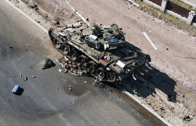 지난 20일(현지시간) 우크라이나 수도 키이우(키예프) 외곽 진입로에 반격을 받은 러시아군 탱크가 널브러져 있다. AFP 연합뉴스