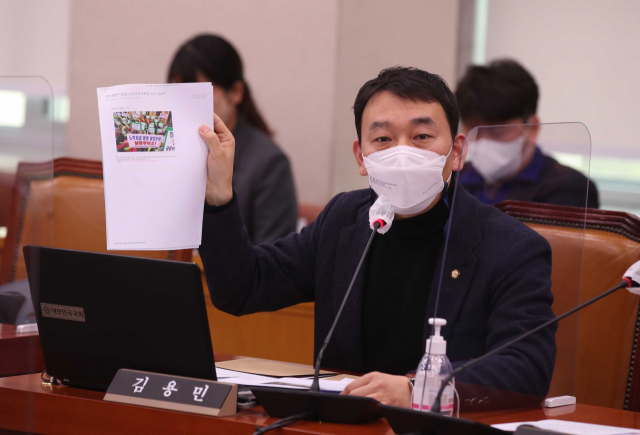 지난 7일 국회에서 열린 법제사법위원회 전체회의에서 더불어민주당 김용민 의원이 부산저축은행의 부실 대출 사건 기사를 들어 보이며 특검 수사를 요구하고 있다. /연합뉴스