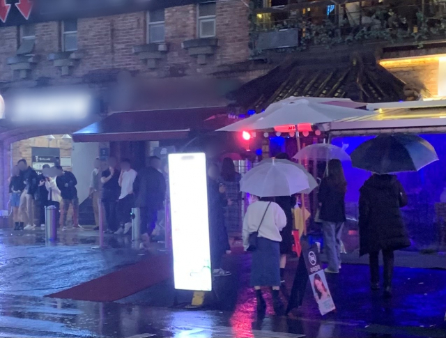 마스크를 제대로 착용하지 않은 시민들이 지난 25일 저녁 서울 강남구 역삼동 인근 먹자 골목 건물 처마마다 모여 담배를 피우고 있다. 김남명 기자
