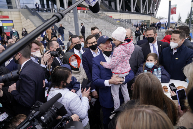 조 바이든 미국 대통령이 26일(현지 시간) 우크라이나 난민들의 임시 거처가 마련된 폴란드 바르샤바 운동장을 찾아 난민 소녀를 안아주고 있다./AP연합뉴스