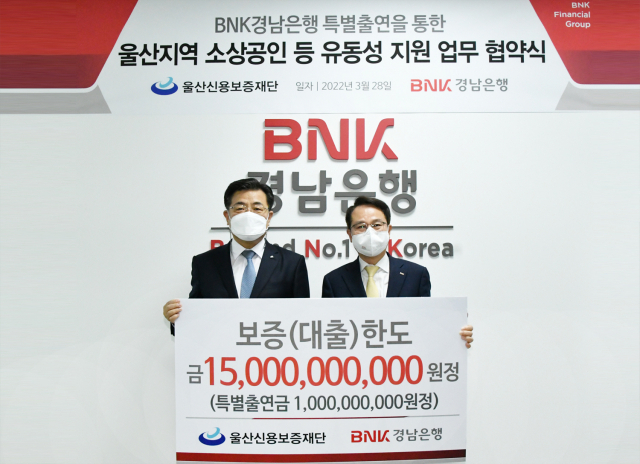 정윤만(오른쪽) BNK경남은행 상무와 김갑수 울산신용보증재단 이사장이 28일 BNK경남은행 울산영업본부에서 열린 ‘울산지역 소상공인 유동성 지원 업무협약’을 체결한 뒤 기념 촬영하고 있다. 사진 제공=BNK경남은행