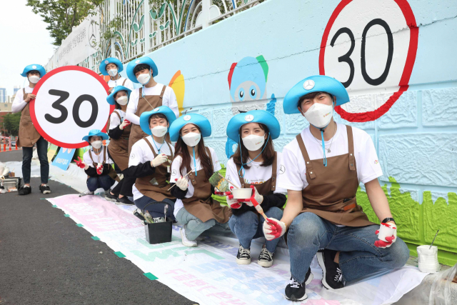 벤츠코리아와 딜러사 임직원들이 학교 환경을 개선하는 ‘올투게더 안심 학교 담벼락 벽화 그리기’ 행사에 참여하고 있다. 사진 제공=벤츠코리아